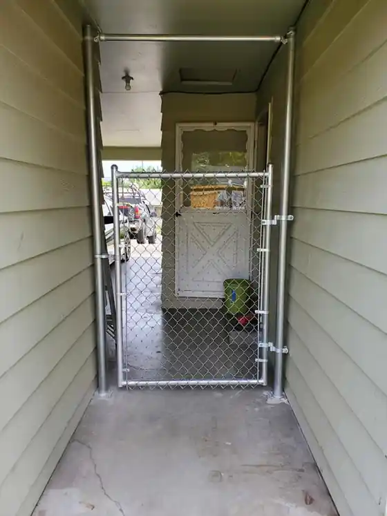 Galvanized chain link walk gate in a covered side passage